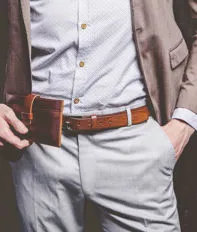 Adatti il ritratto dell'uomo di modello bello del giovane uomo d'affari vestito in vestito marrone elegante